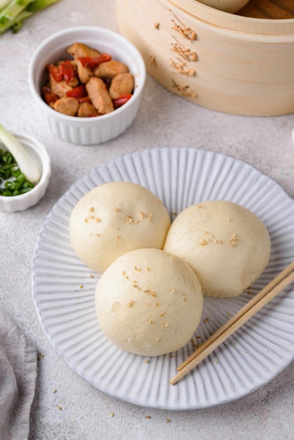 Qual è la tecnica per preparare dei baozi cinesi al vapore con ripieno di maiale e cipollotti?